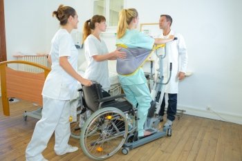 Medical staff helping woman to standing