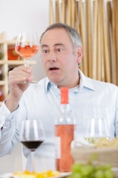 surprised man tasting a glass of rose