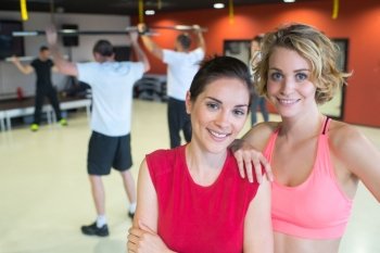 happy women posing in a gym and smiling