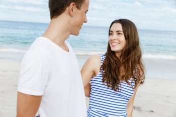 Romantic young couple on the beach. Romantic young couple on the beach standing next to the ocean