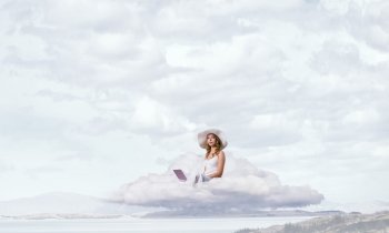 Lady using laptop. Young lady sitting on cloud with laptop on knees