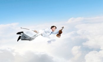 Business break. Young businessman flying in sky and playing violin