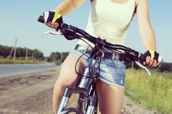 Close up of young beautiful woman riding a bicycle in a park