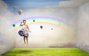 Buoyant and happy. Little cute girl jumping high among balloons flying in sky