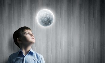 Full moon. Cute boy of school age looking at moon