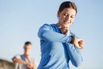 Runner woman with heart rate monitor running on beach. Young runner woman with heart rate monitor running on beach