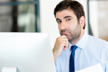 Young businessman in office thinking about something