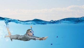 Woman under water. Young businesswoman in suit and diving mask swimming under water