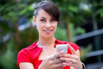 Portrait of businesswoman with mobile phone. Portrait of beautiful business woman in red dress holding her mobile