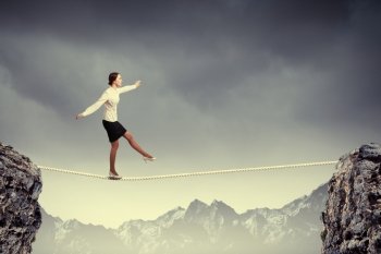 Businesswoman balancing on rope. Image of businesswoman balancing on rope. Risk concept