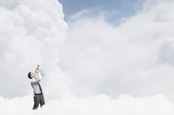 Businessman play pipe. Young businessman on cloud in sky playing pipe