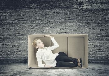 Girl in box. Young businesswoman trapped in carton box