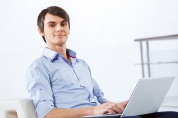 Man browsing web. Young handsome businessman sitting and using laptop