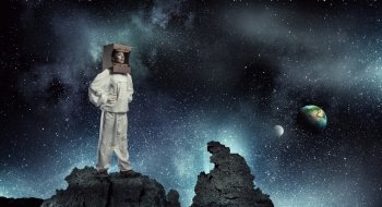 Dreaming to explore space. Young woman with carton box on head imagine she is astronaut. Elements of this image are furnished by NASA