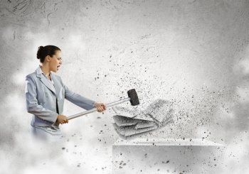 Computer addiction. Image of businesswoman crushing with hammer pile of keyboards