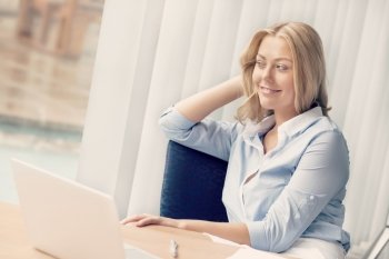 Businesswoman sitting at desk relaxed in offfice