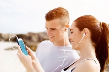 Couple of runners with mobile smart phones outdoors. Young couple of runners with mobile smart phone outdoors on beach