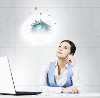 Pensive woman at work. Young attractive woman sitting at office desk and looking thougthfully up. Elements of this image are furnished by NASA