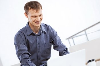 Man browsing web. Young handsome businessman sitting and using laptop