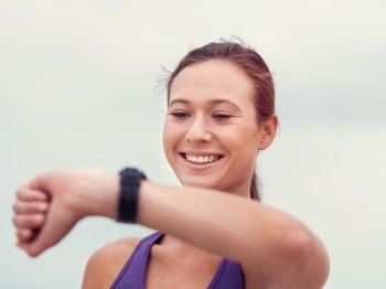 Sporty young woman looking at her wristwatch