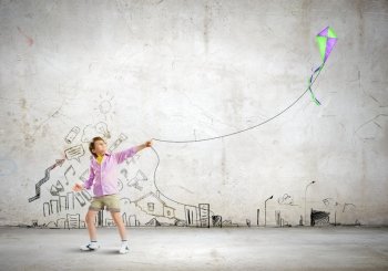 Boy with kite. Little boy playing with kite against wall background. Childhood concept