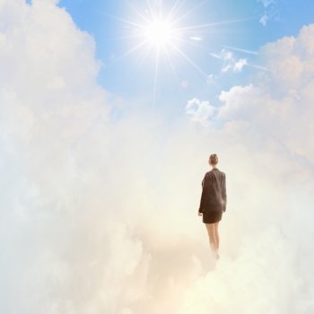 Success in business. Back view of businesswoman standing on cloud high in sky