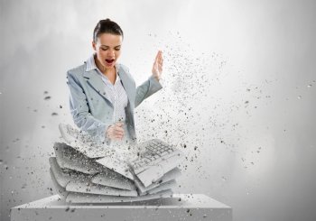 Computer addiction. Image of businesswoman crushing with hand pile of keyboards