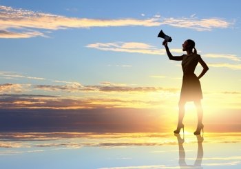 Woman with megaphone. Silhouette of woman at sunset screaming in megaphone