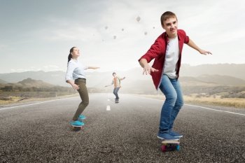 Teenagers ride skateboard. Active teenagers riding skateboard on asphalt road