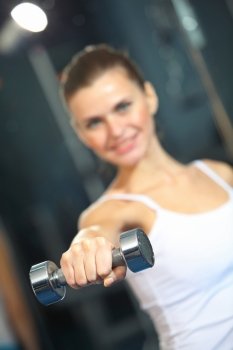 Sport girl. Image of fitness girl in gym exercising with dumbbells