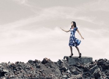 Woman in blue dress. Young woman in blue dress walking among city ruins