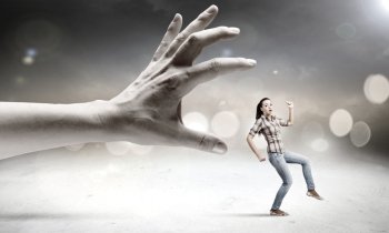 Woman escape from hand. Young woman in casual running away from big hand
