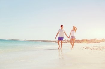 Romantic young couple on the beach. Romantic young couple on the beach walking along the shore