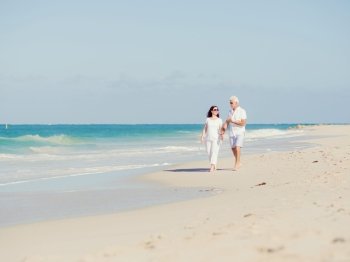 Couple walking on the beach. Walk along the waves