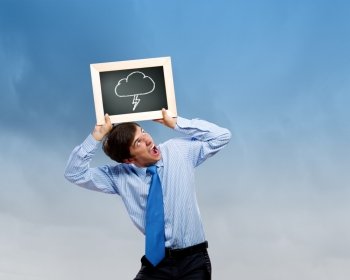 business troubles. Young businessman holding frame with weather drawings