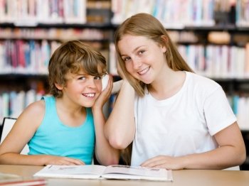 Teenage girl  and her brother with books in library. Teenage girl and her brother with books