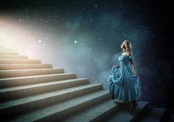 Girl in blue dress. Young blond woman in blue dress walking up the stairs