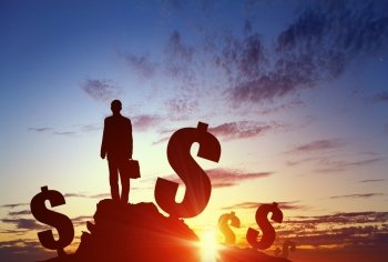 Achieving financial success. Silhouette of businessman standing with back on hill top
