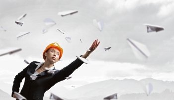 Female architect woman. Young engineer woman reaching hand and paper airplanes flying around