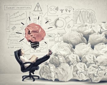 In search of great idea. Businesswoman in chair and many crumpled balls of colorful paper as creativity sign