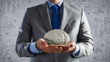 Mental health. Close up of businessman holding human brain in palms