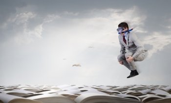 Businessman diver. Young businessman in suit and diving mask jumping in pile of books