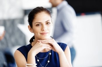 Attractive office worker sitting at desk. Attractive woman sitting at desk in office with coffee