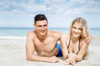 Romantic young couple on the beach. Romantic young coupleon the beach looking at camera