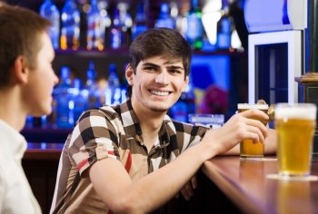 Sport bar. Two young men sitting at bar and talking