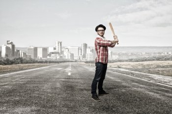 Hipster guy with bat. Young hipster guy with bat on asphalt road