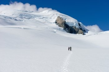 New Zealand. People walking among snows of New Zealand mountains