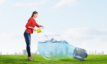 Fresh crystal water. Young woman pouring water from yellow bucket