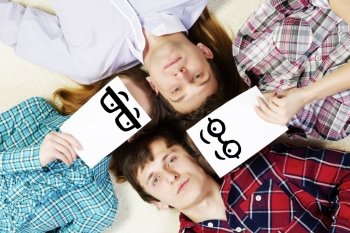 Group of young smiling people lying on floor in circle with phone symbols. Let’s be friends