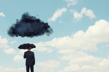 Pessimist in business. Back view of businessman with black umbrella and black cloud above